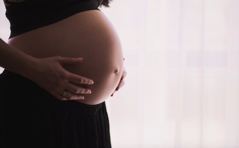 Pregnant woman receiving chiropractic care during prenatal session
