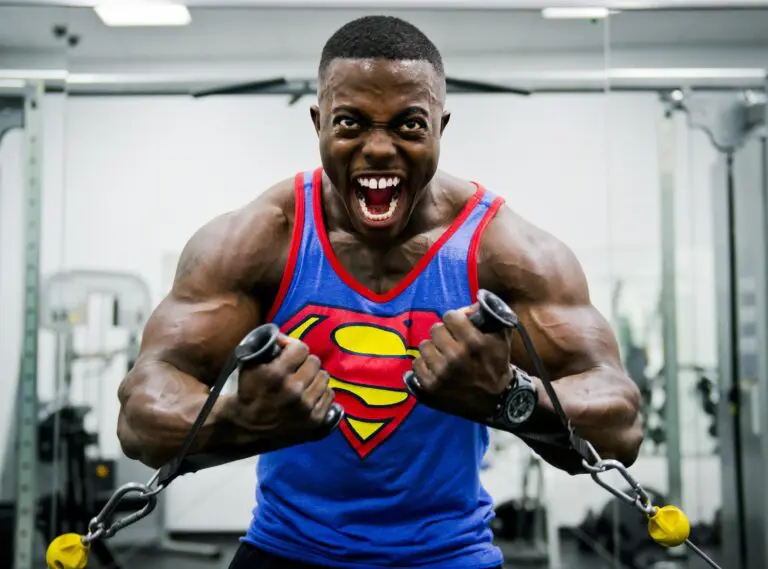 Bodybuilder lifting weights exhibiting physical stress