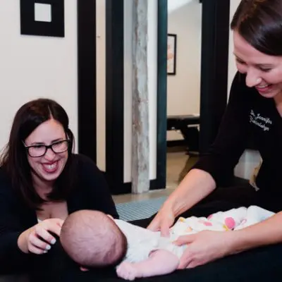 Chiropractor performing gentle adjustment on a baby