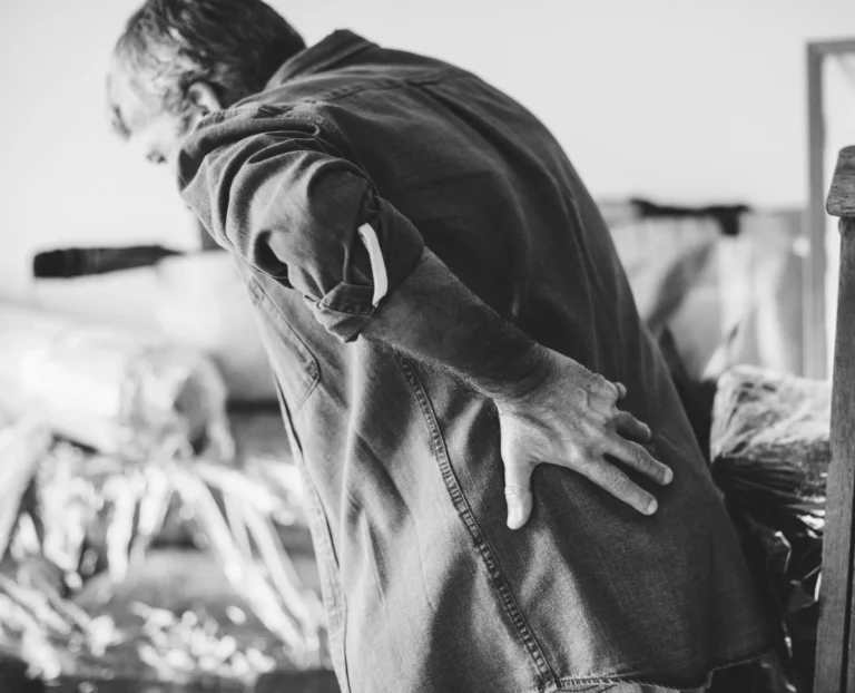 Man holding his lower back showing signs of back pain