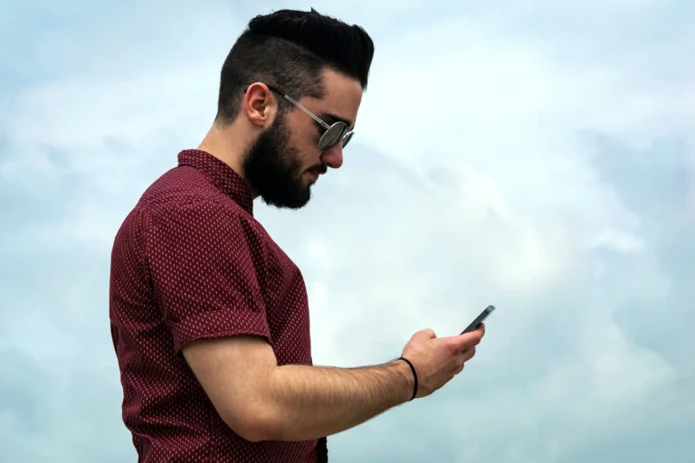 Adult looking at cellphone while sitting