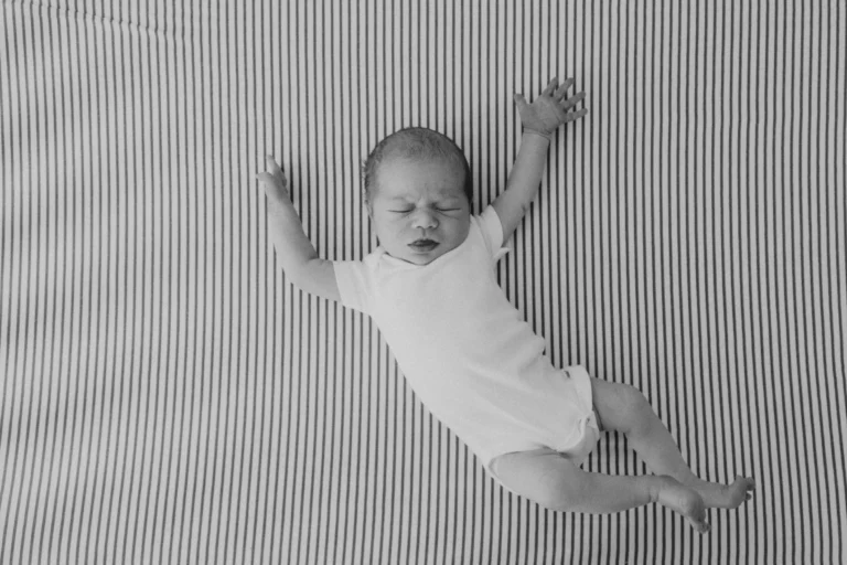 Newborn baby held by parents in a cozy setting