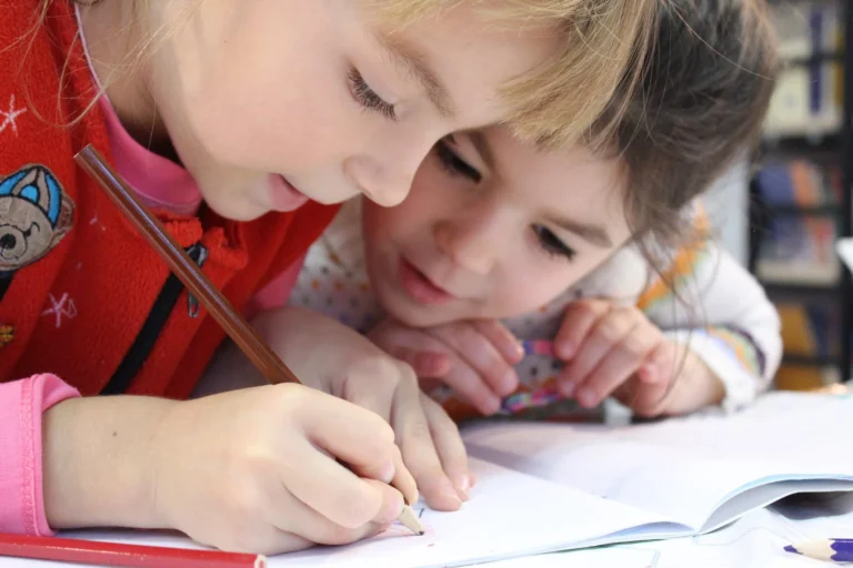 Young girl drawing with a pencil on paper