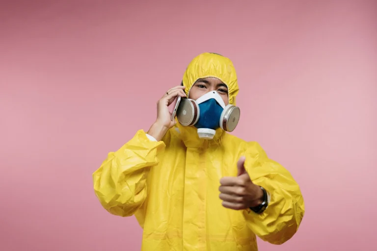 Person wearing yellow coveralls standing indoors