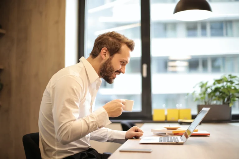 Woman sitting at her home office desk adjusting her posture to avoid back pain