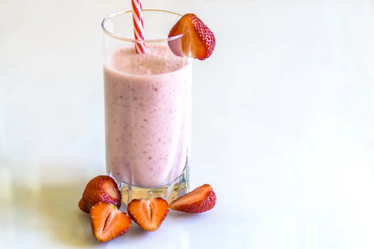 A bowl with oatmeal topped with sliced banana, raspberries, and walnuts